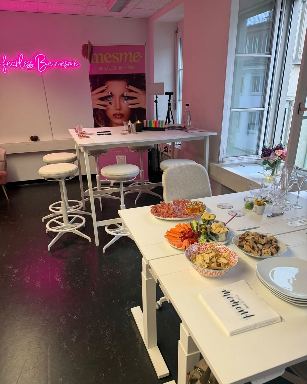 The room at mesme HQ before the evening, with a pink neon sign, high tables and an apéro laid out